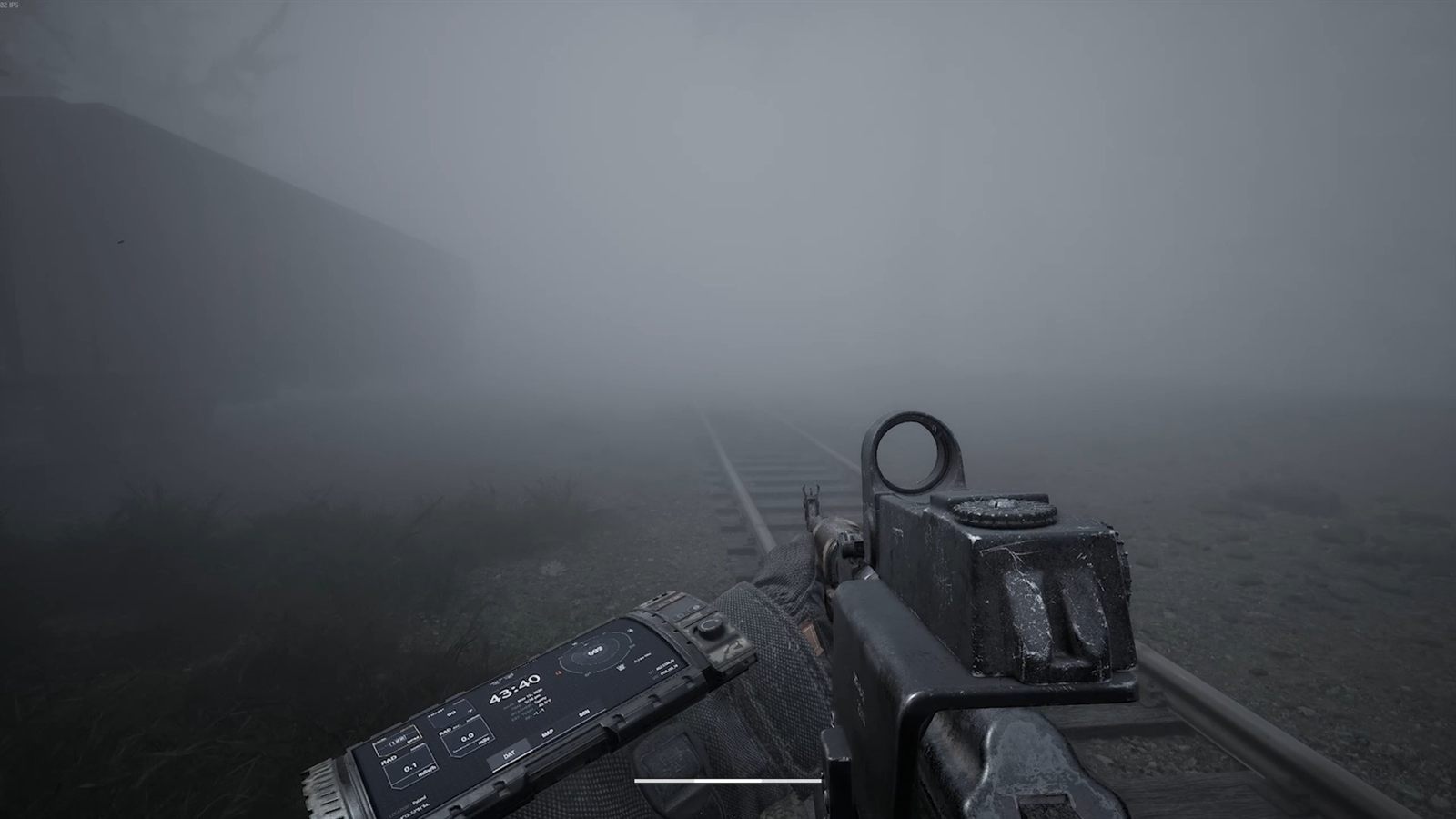 A railway line and a line of freight wagons fading into dense fog
