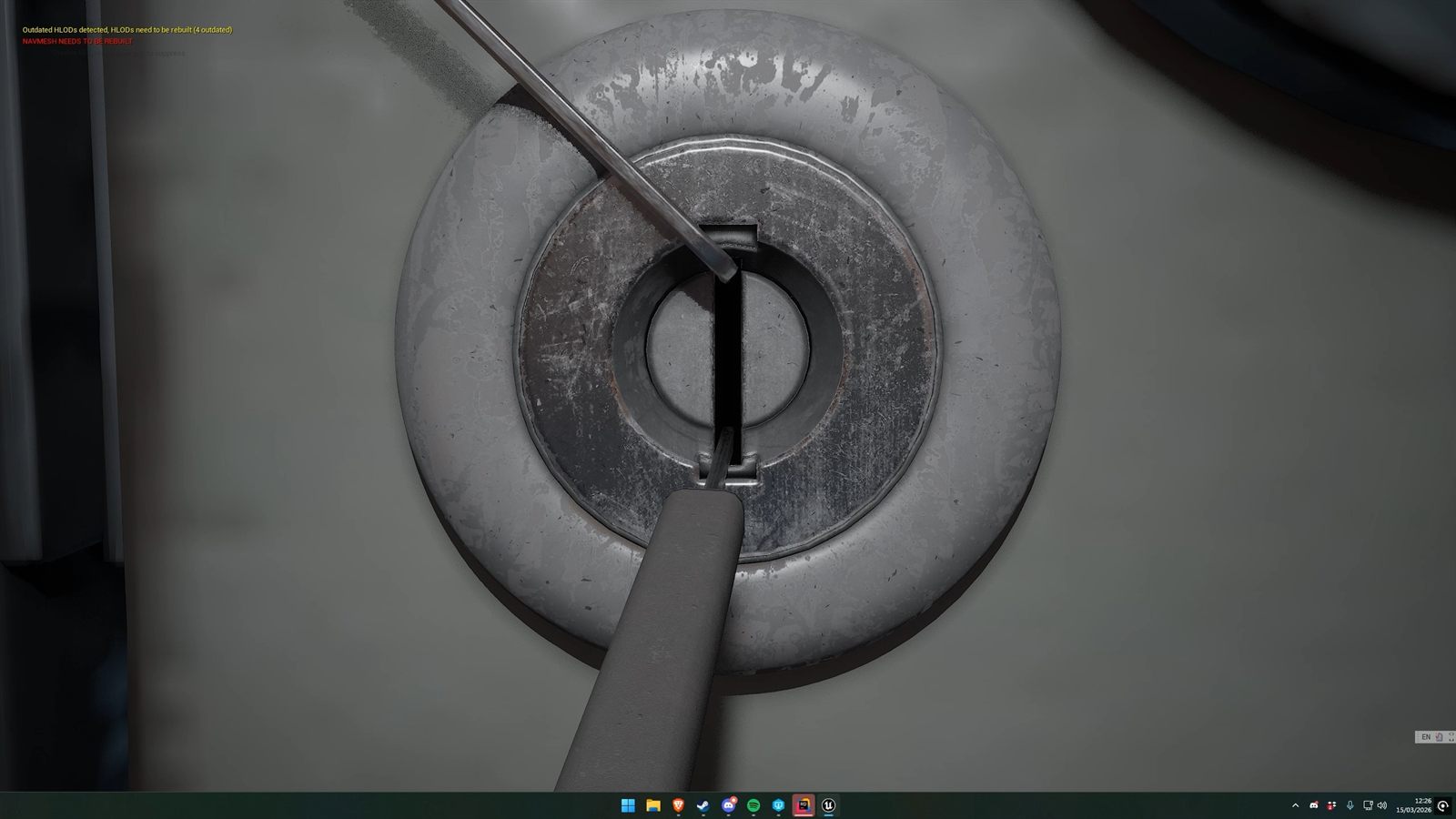 A close-up of a pick and tension tool inserted into a round metal lock
