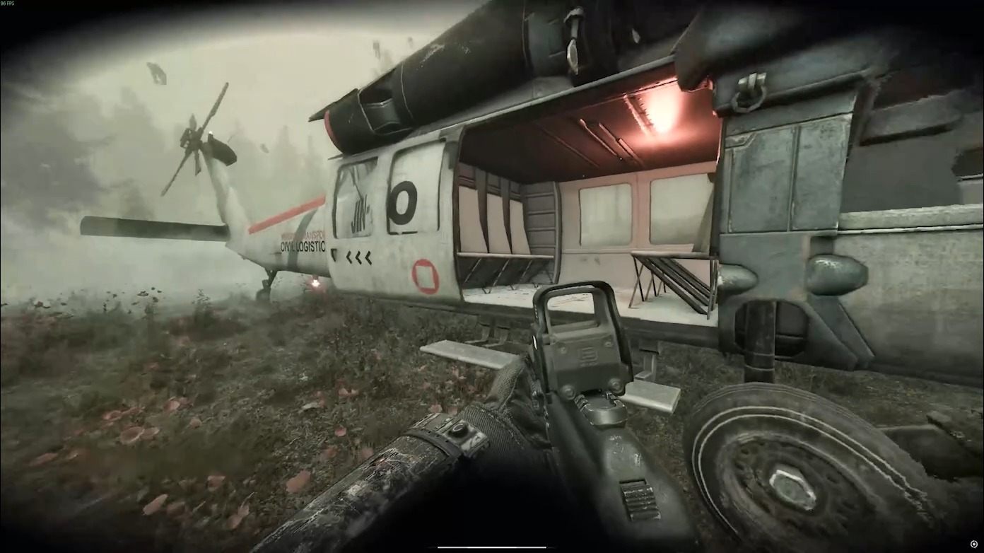 An operator with a rifle next to a white extraction helicopter landed in a misty field