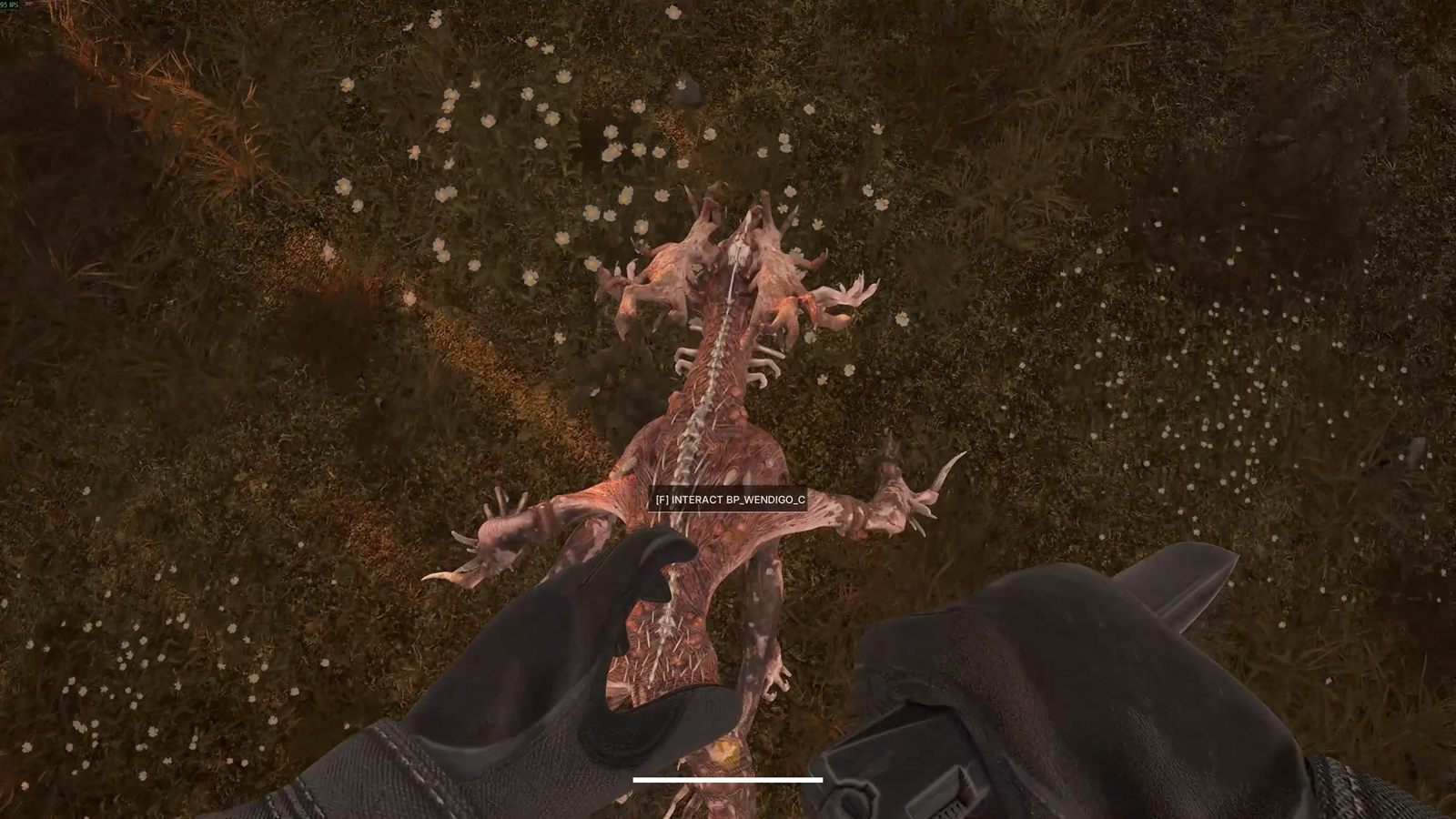 A pale, spined creature crouched on a forest floor, seen from an operator's point of view with gloved hands raised