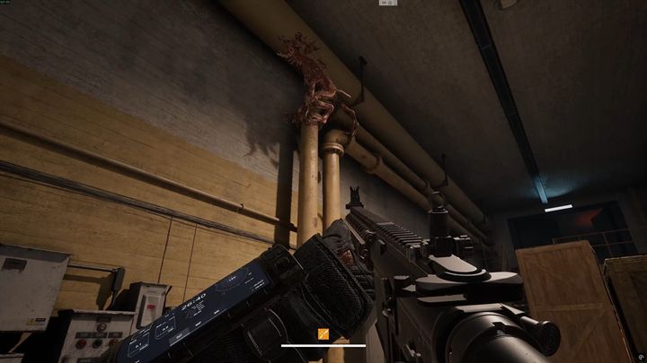 A pale creature clinging high on a bunker wall above an operator