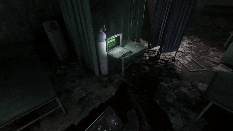 A laptop glowing on a desk in a dark, wrecked room, seen over an operator's shoulder