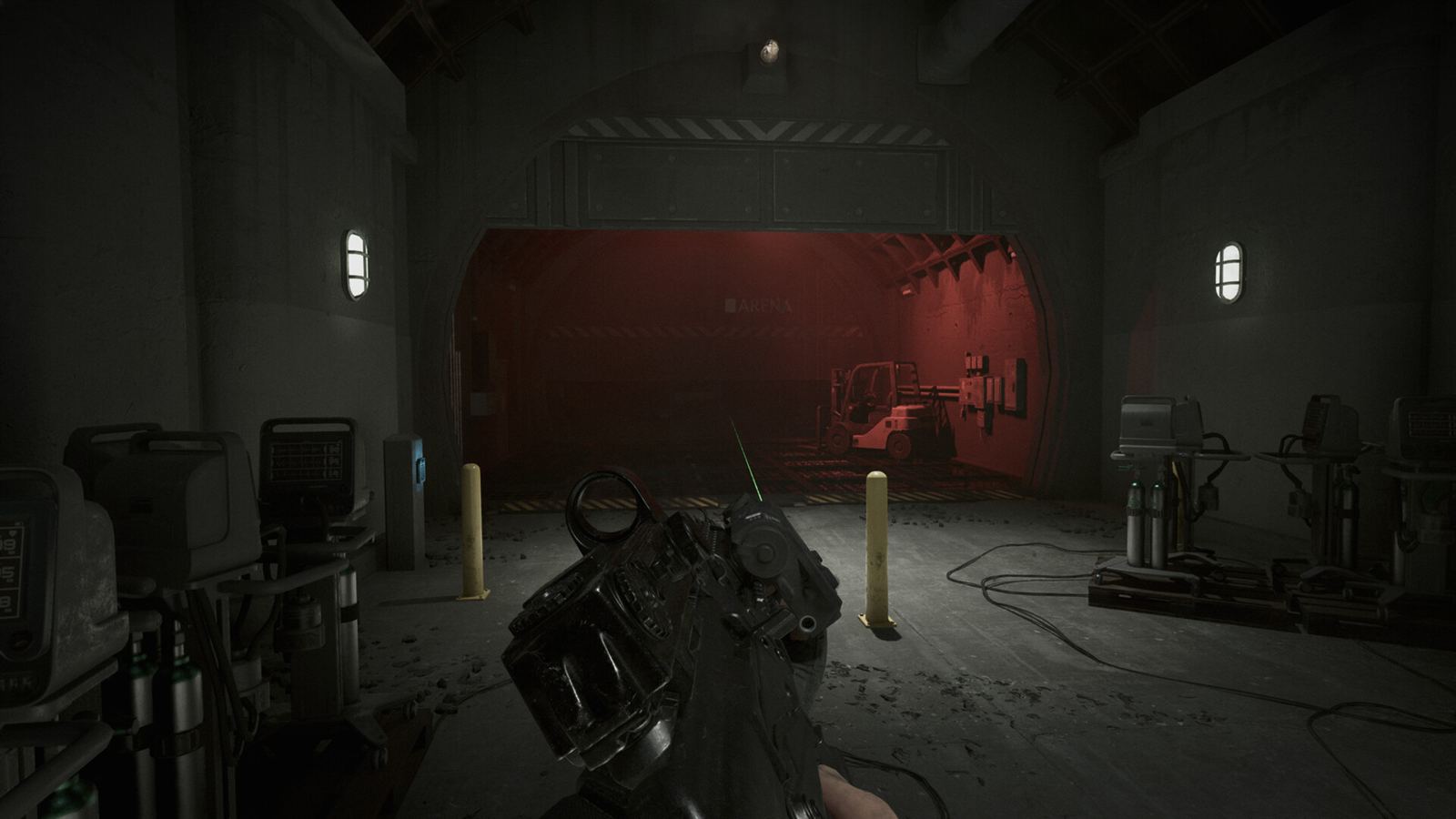 A bunker vehicle bay washed in red alarm light, bollards and cables across the floor