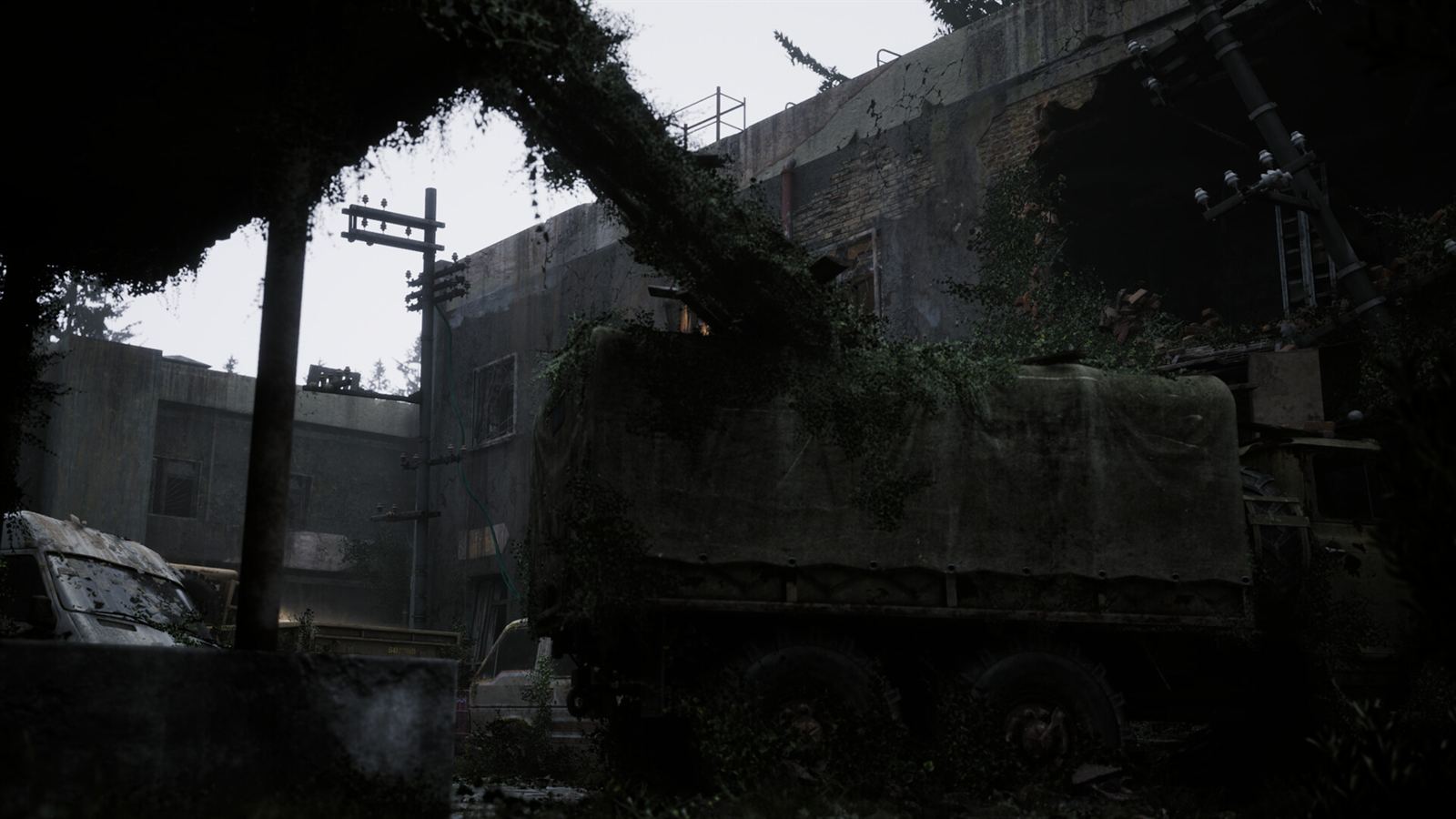 A military truck swallowed by moss and saplings against a collapsing concrete plant