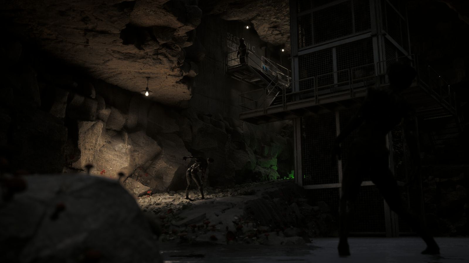 A wooden structure built inside a vast cave, lit by a single hanging lamp