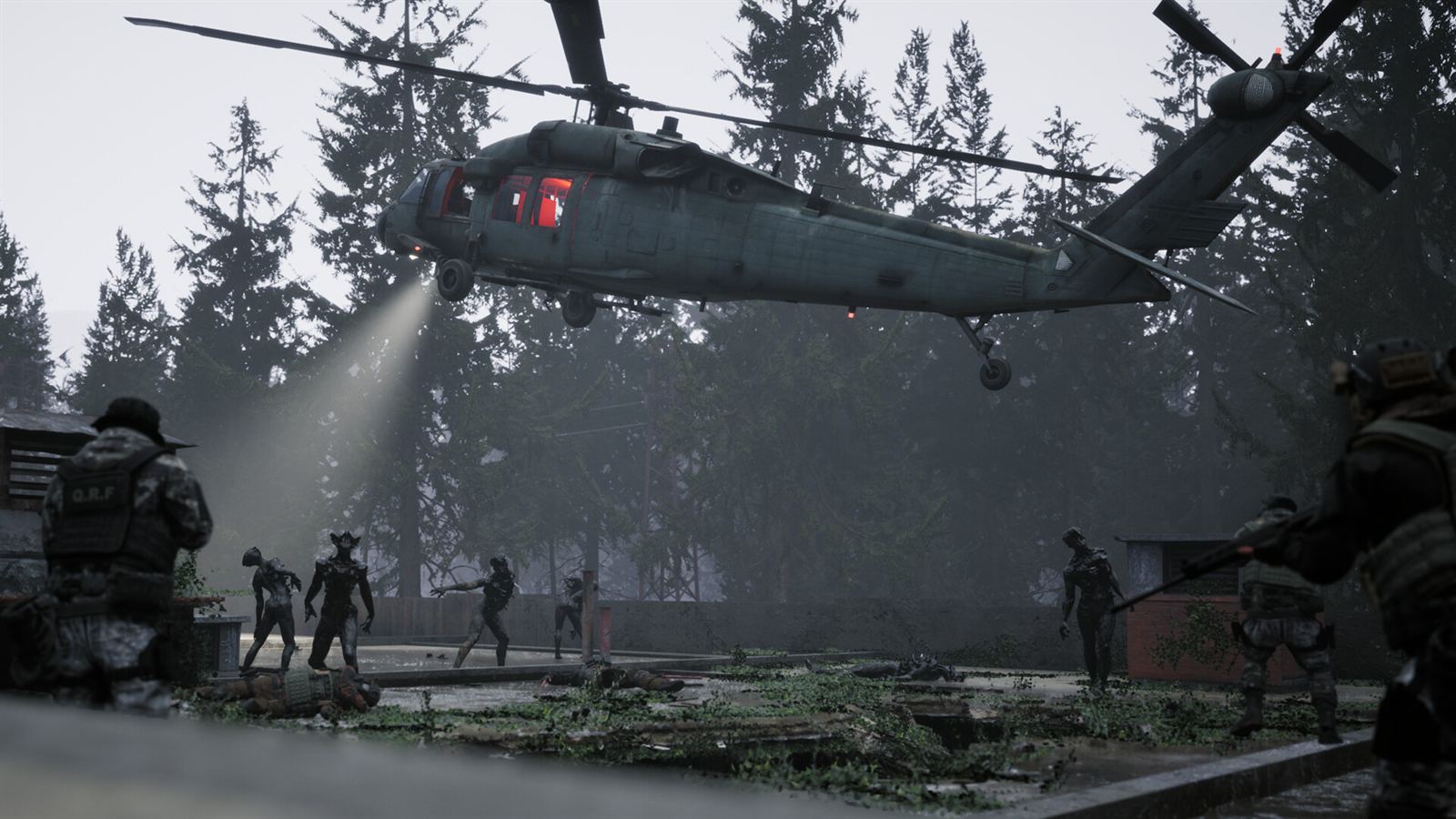 Operators holding a clearing as the extraction helicopter drops its searchlight through the fog